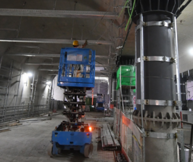 地铁昌平线南延现场，工人使用升降平台车安装站厅设备