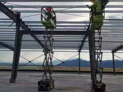剪叉式升降平台车协助工人安装钢结构